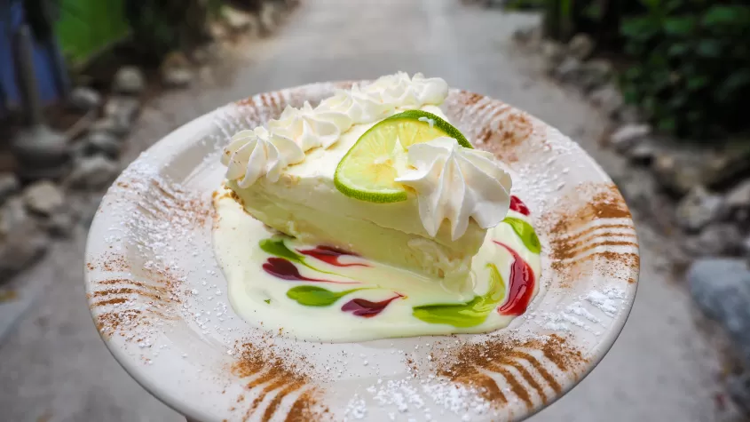 hand holding plate with slice of key lime pie.