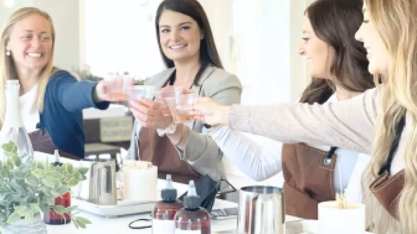 Ladies making custom scented candles while sipping wine