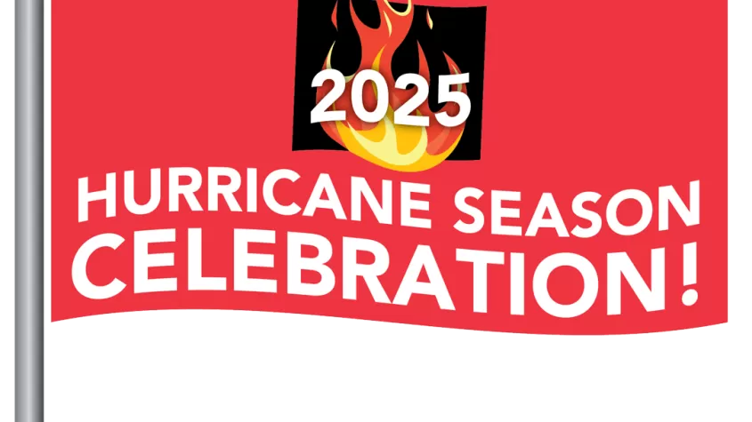 red flag with The end of Hurricane Season Celebration on it and a burn barrel in the middle