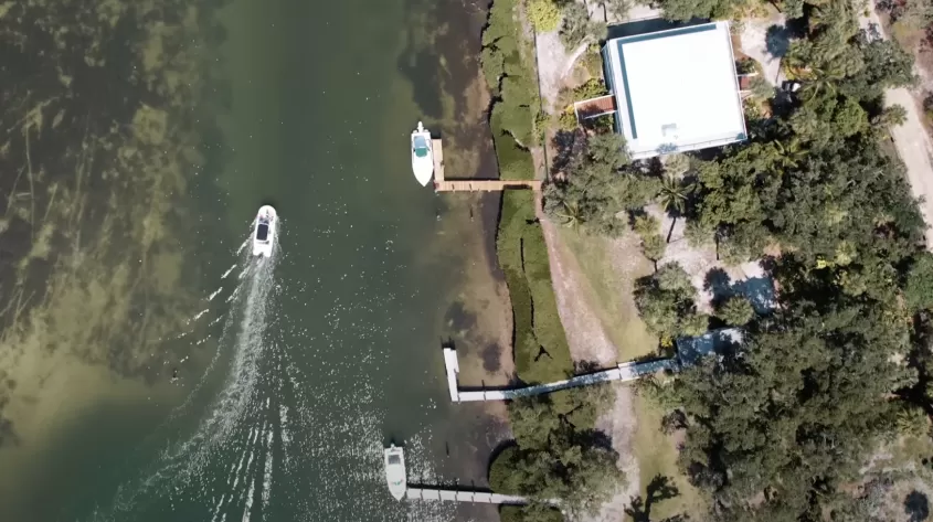 A drone image featuring a boat pulling up to a dock