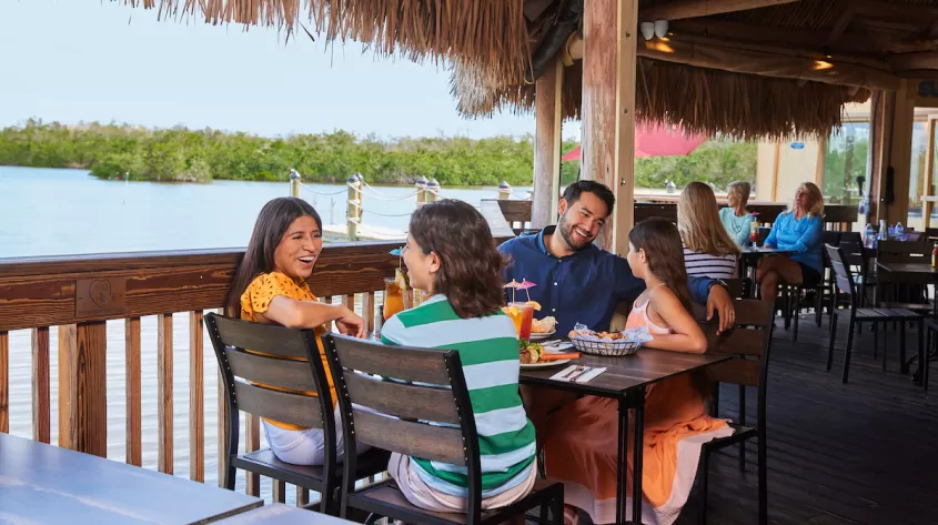 A family enjoys at meal on an outdoor deck at Coconut Jacks in Bonita Springs