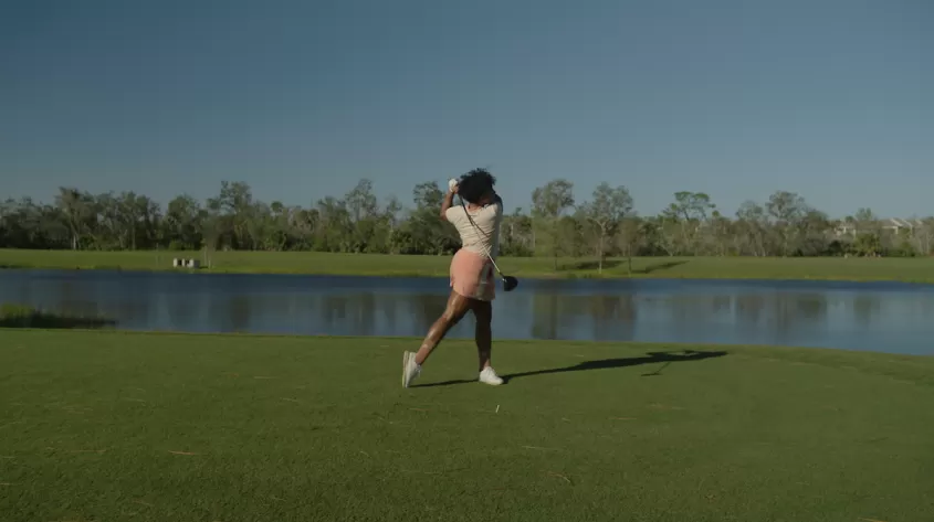 A woman strikes a ball at Salt Leaf Golf Preserve